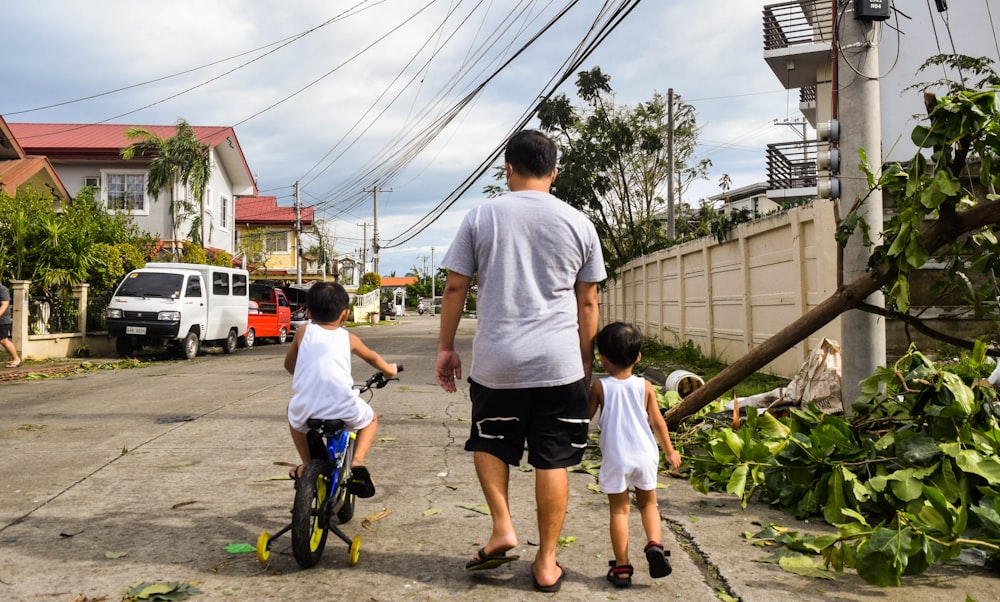 a man and two children walking down a street