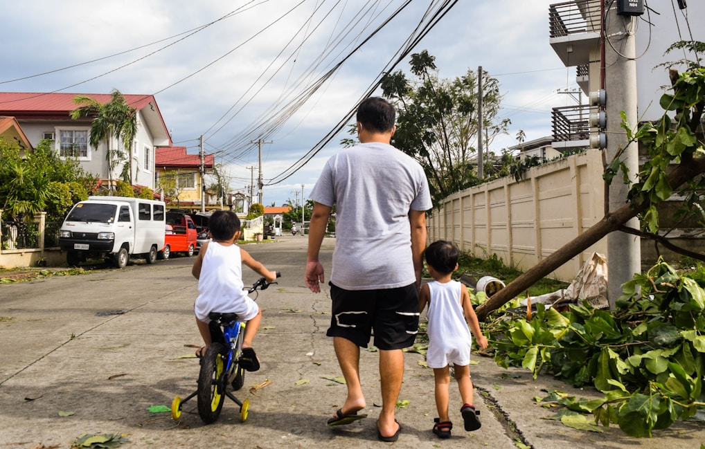 a man and two children walking down a street