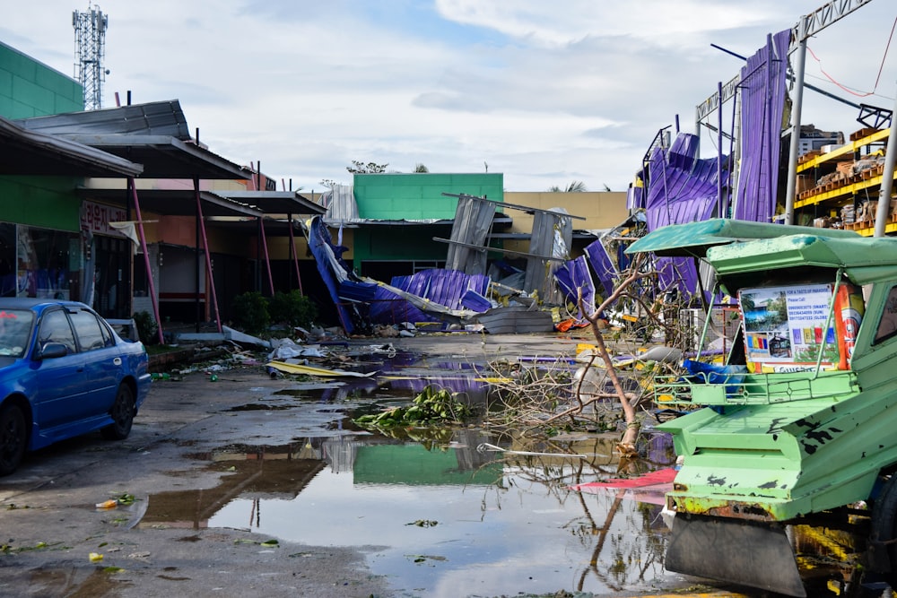 a blue car parked next to a pile of junk