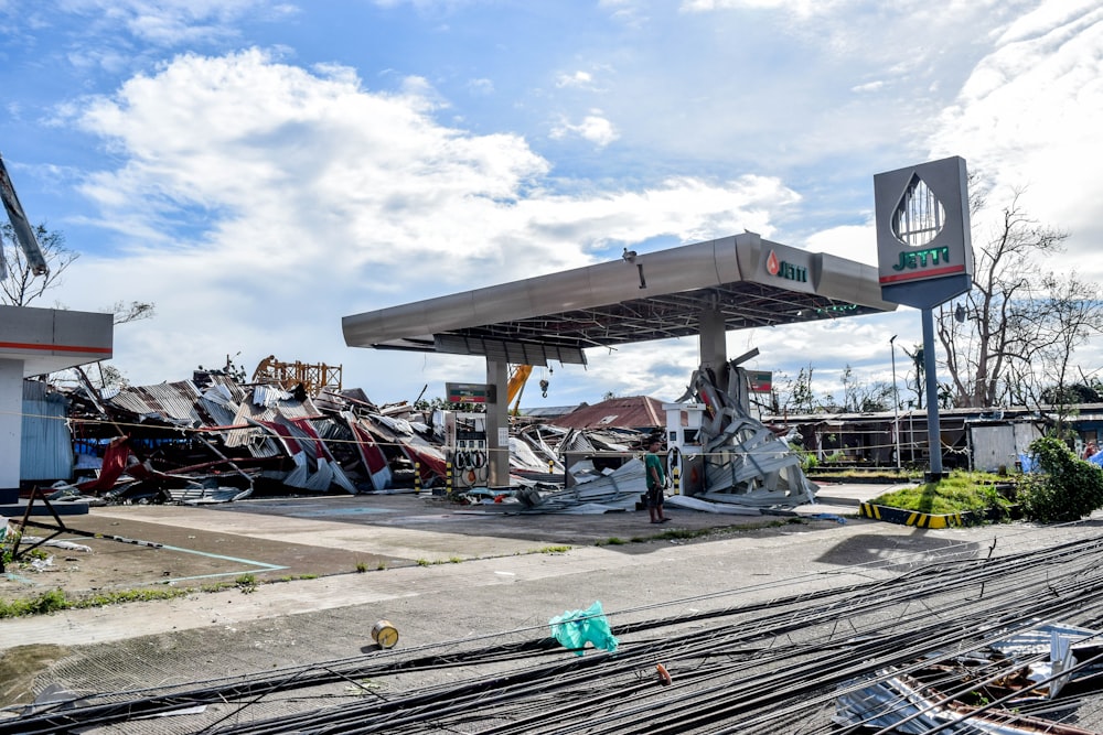 a gas station with a pile of junk in front of it