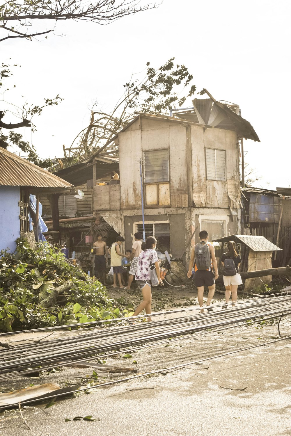 a group of people walking in front of a run down house