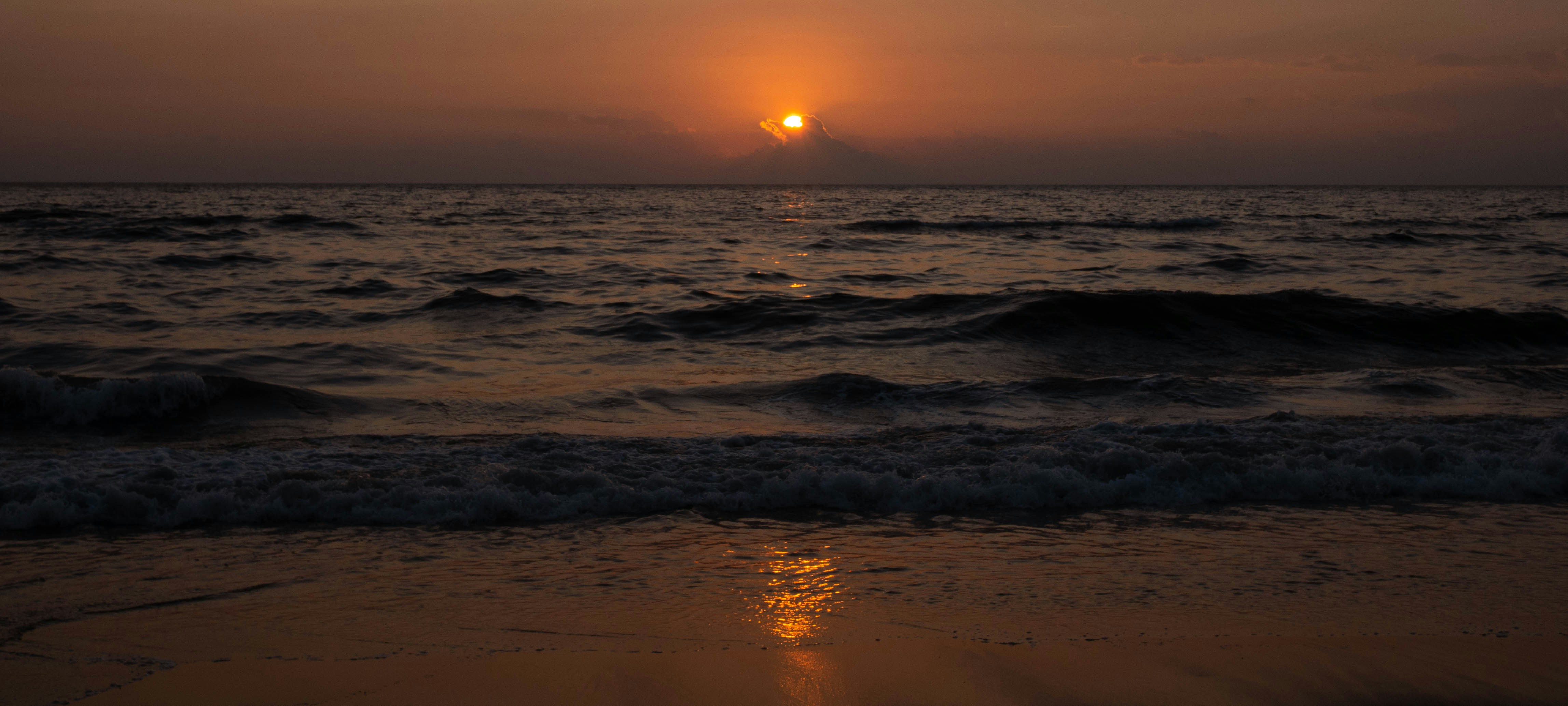 El sol se está poniendo sobre el océano en una playa