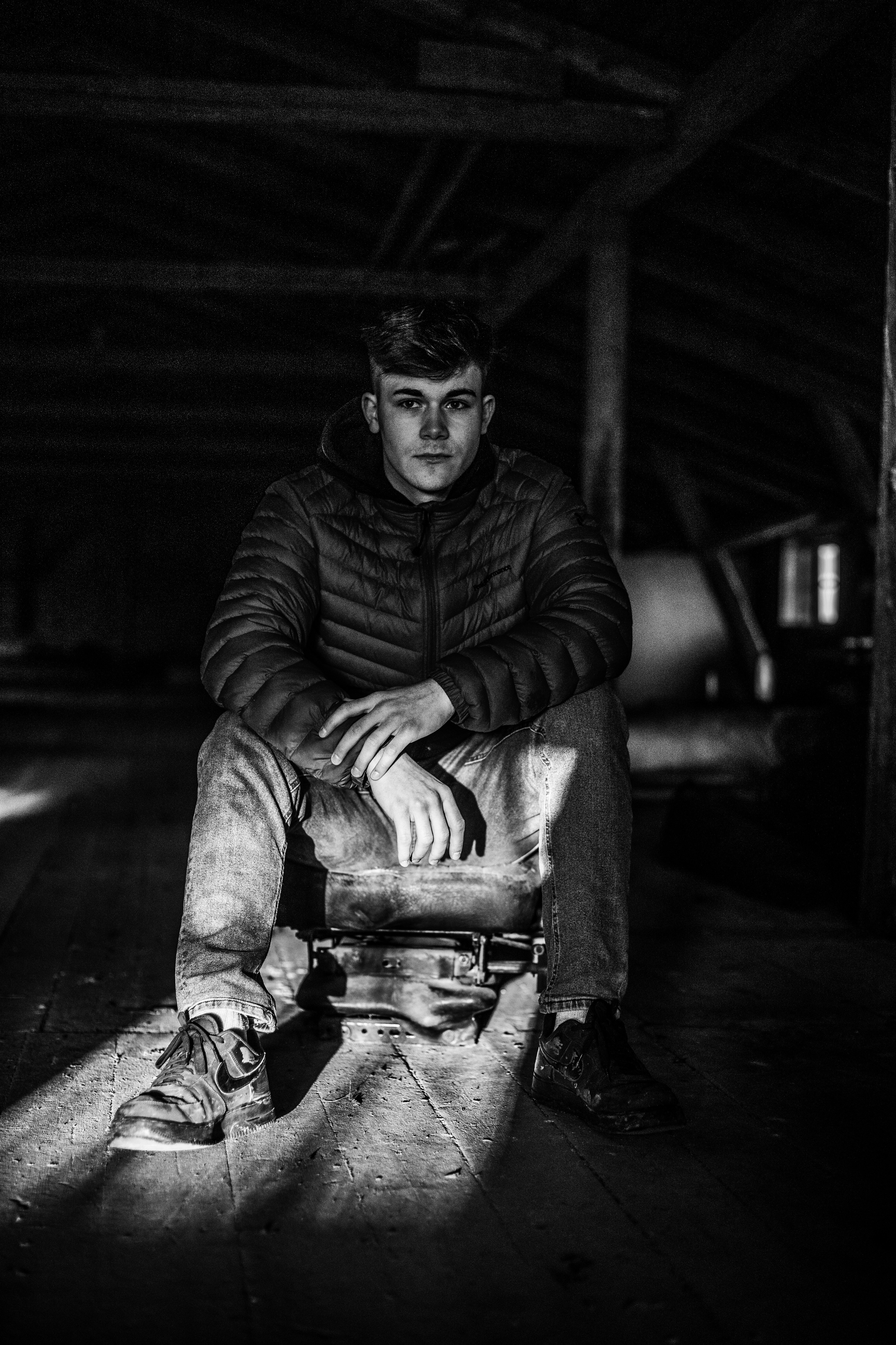 Una foto en blanco y negro de un hombre sentado en una maleta