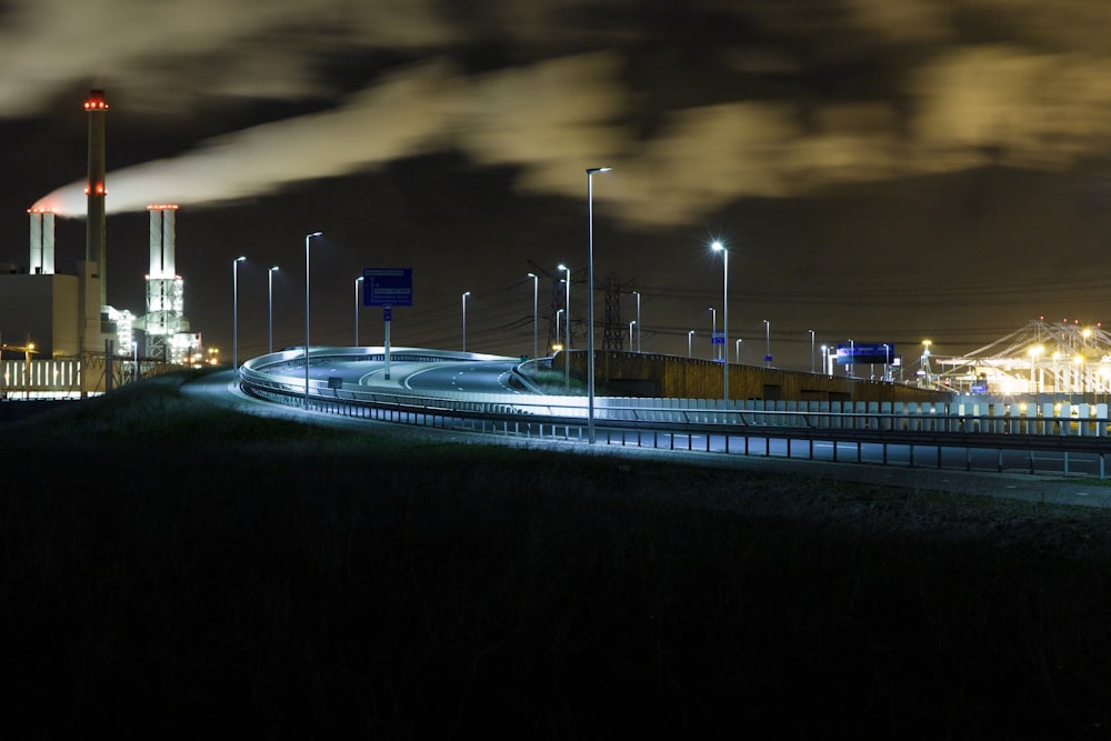 a night scene of a factory with smoke stacks