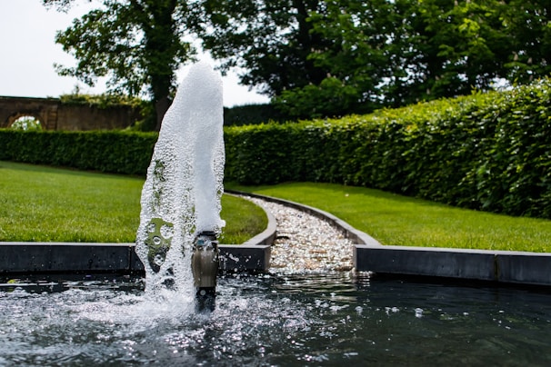 a fire hydrant spewing water in a garden