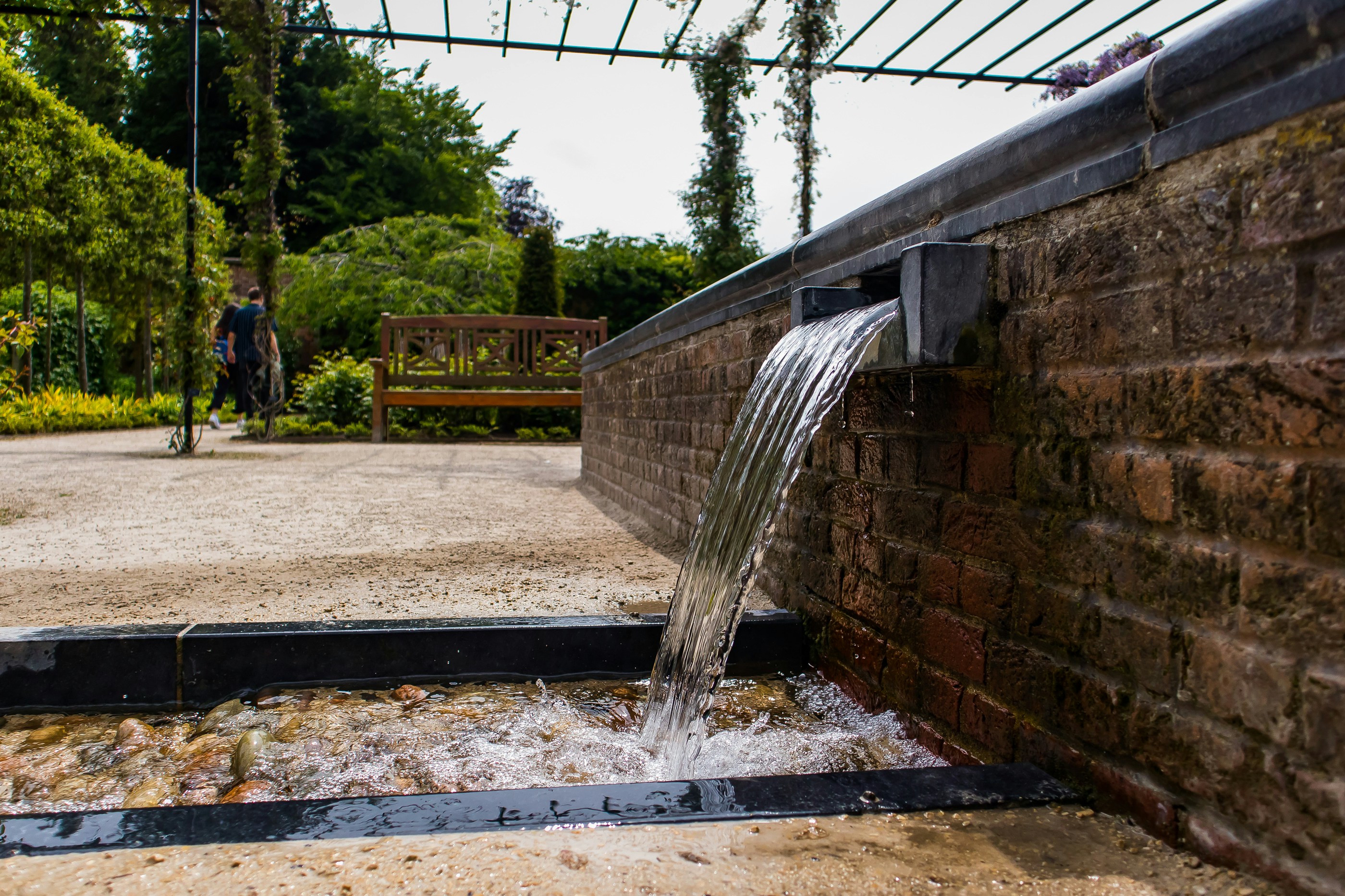 a stream of water coming out of a brick wall
