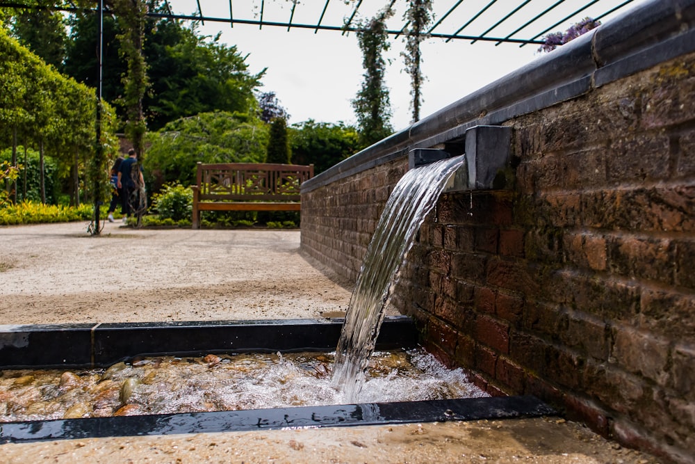 a stream of water coming out of a brick wall