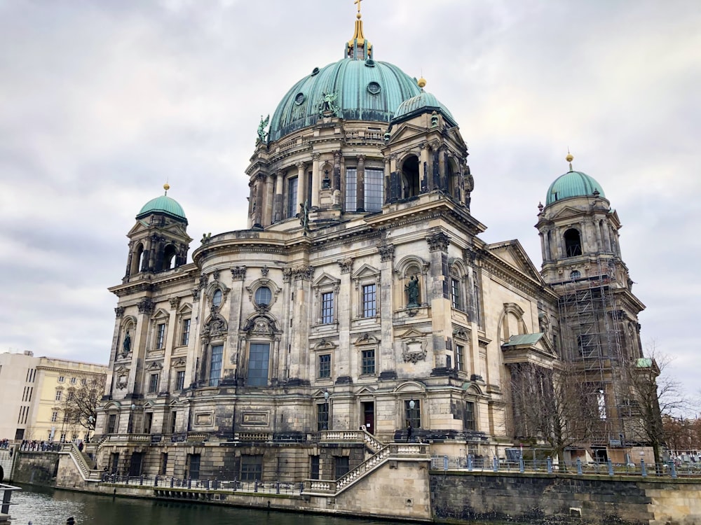 a large building with two towers next to a body of water