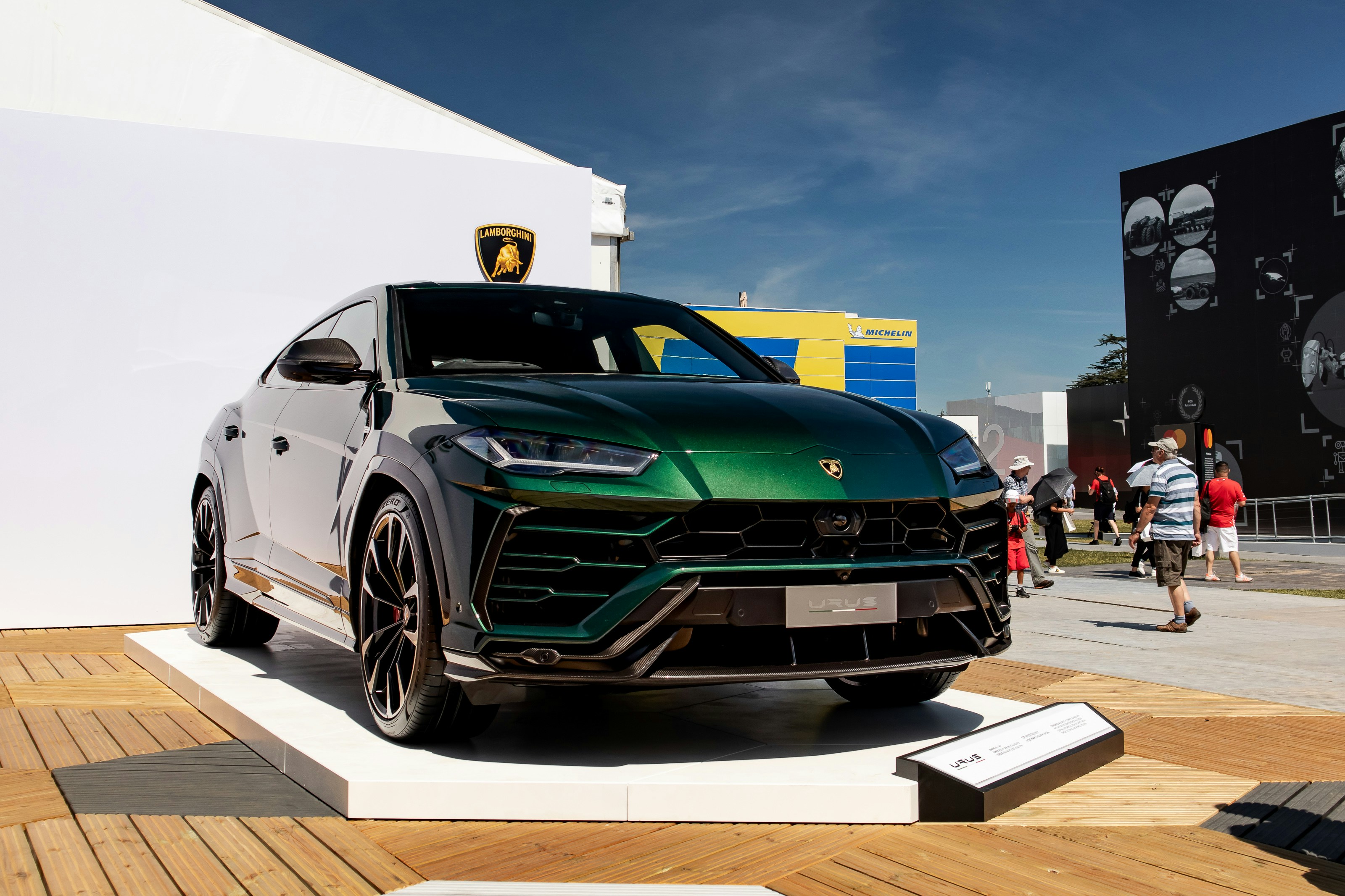 Un SUV Green Lamb parcheggiato in cima a una piattaforma di legno