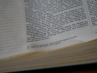 Close-up view of an open book displaying text printed in black on white pages with visible sections of text and page edges.