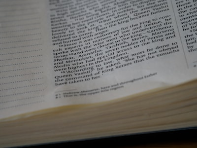 Close-up view of an open book displaying text printed in black on white pages with visible sections of text and page edges.