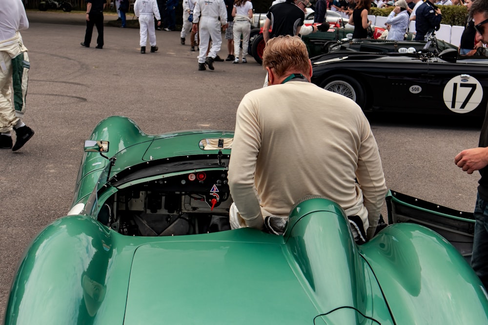 a man sitting on top of a green race car