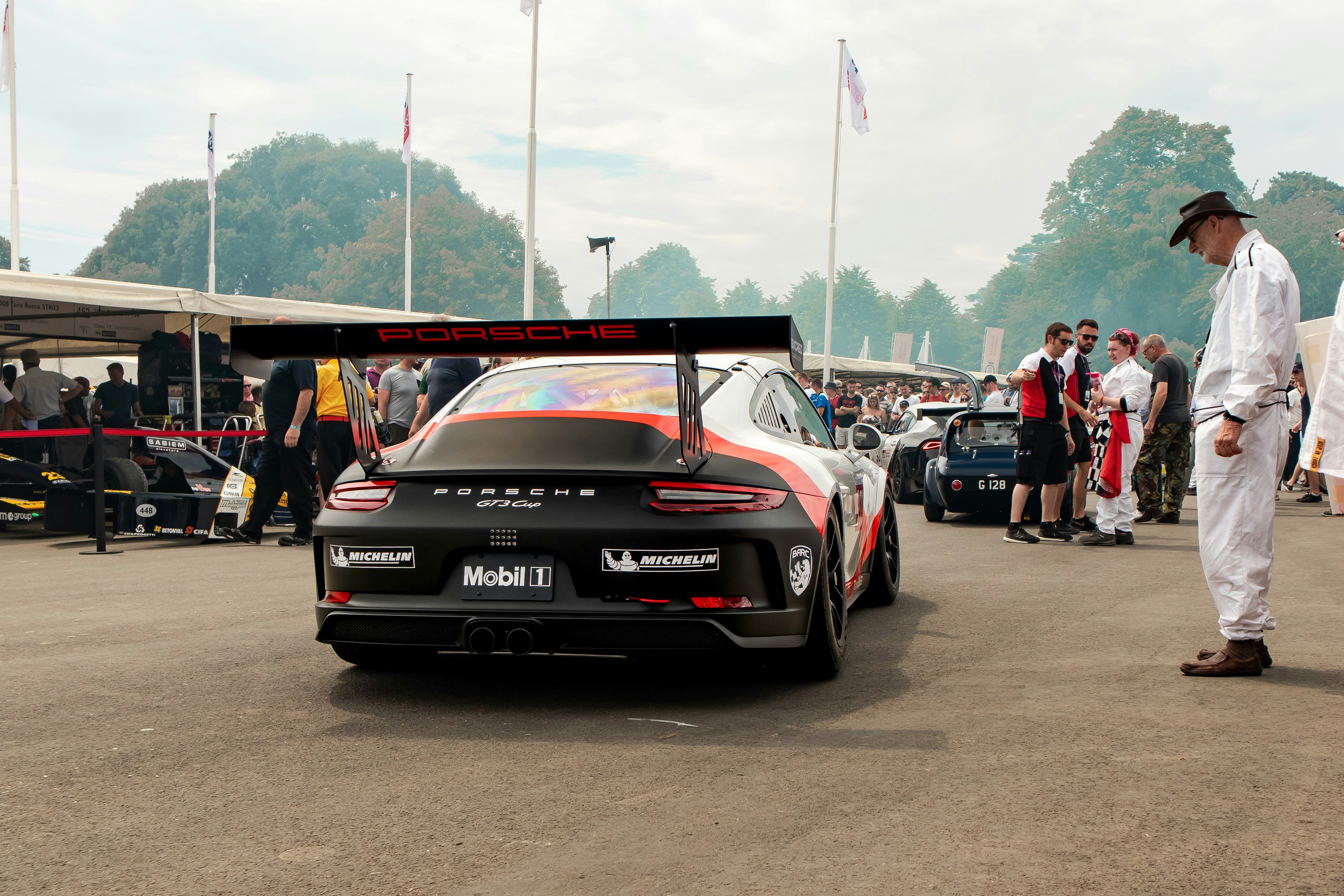 Un uomo in piedi accanto a una macchina in un parcheggio