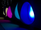 Softly illuminated sacred ecological symbols floating in a dark, spacious environment with subtle neon green accents.