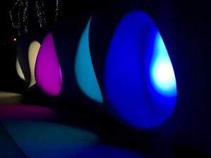 A panoramic view of the VR gallery's cosmic-themed 3D space with glowing blue hues and floating art pieces.