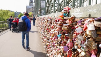a man is walking past a wall covered with padlocks