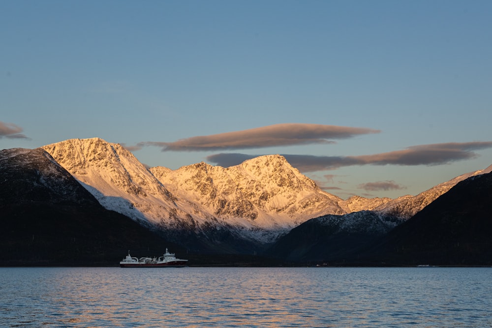 a boat is in the water with mountains in the background