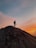 A happy traveler standing on a sand dune at sunset in the Sahara Desert.