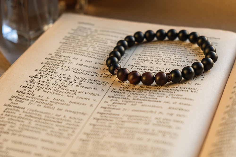 a beaded bracelet sitting on top of an open book