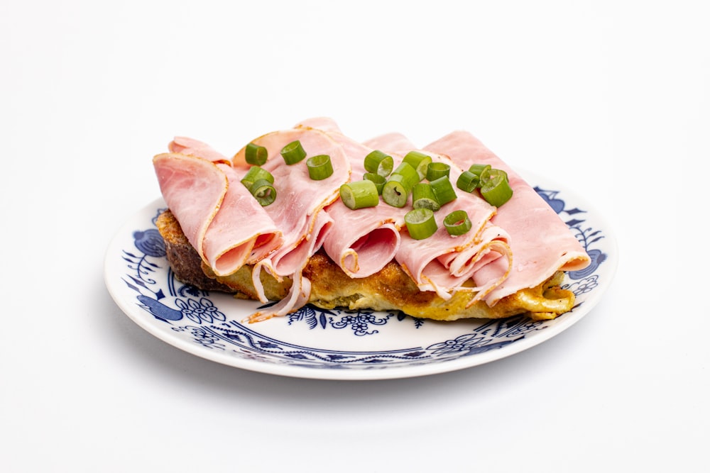 a plate with ham and peas on it