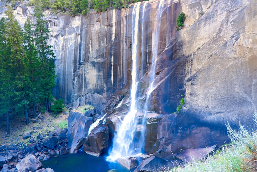 a waterfall with a blue pool in the middle of it