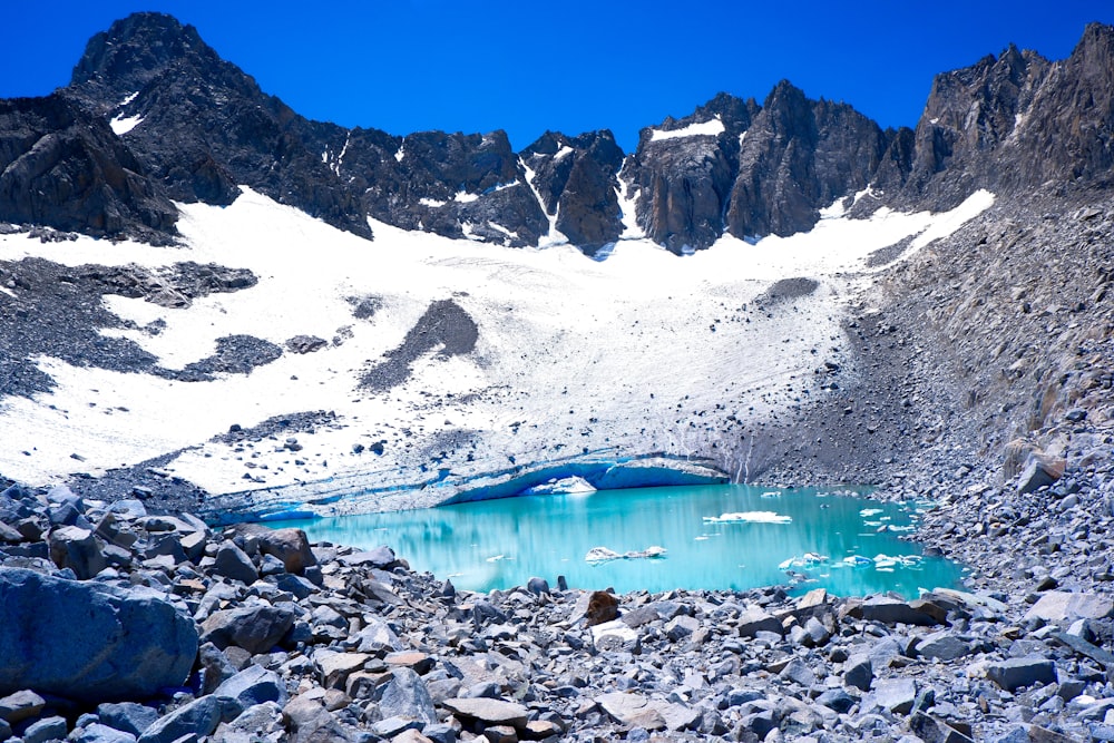 a mountain lake surrounded by rocks and snow