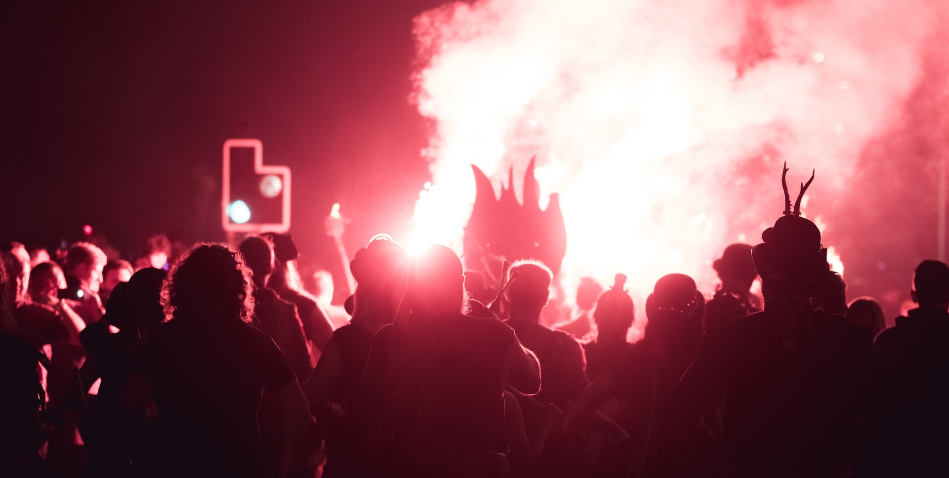 a crowd of people standing next to a traffic light