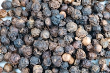 a close up of a pile of black pepper