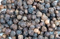 a close up of a pile of black pepper