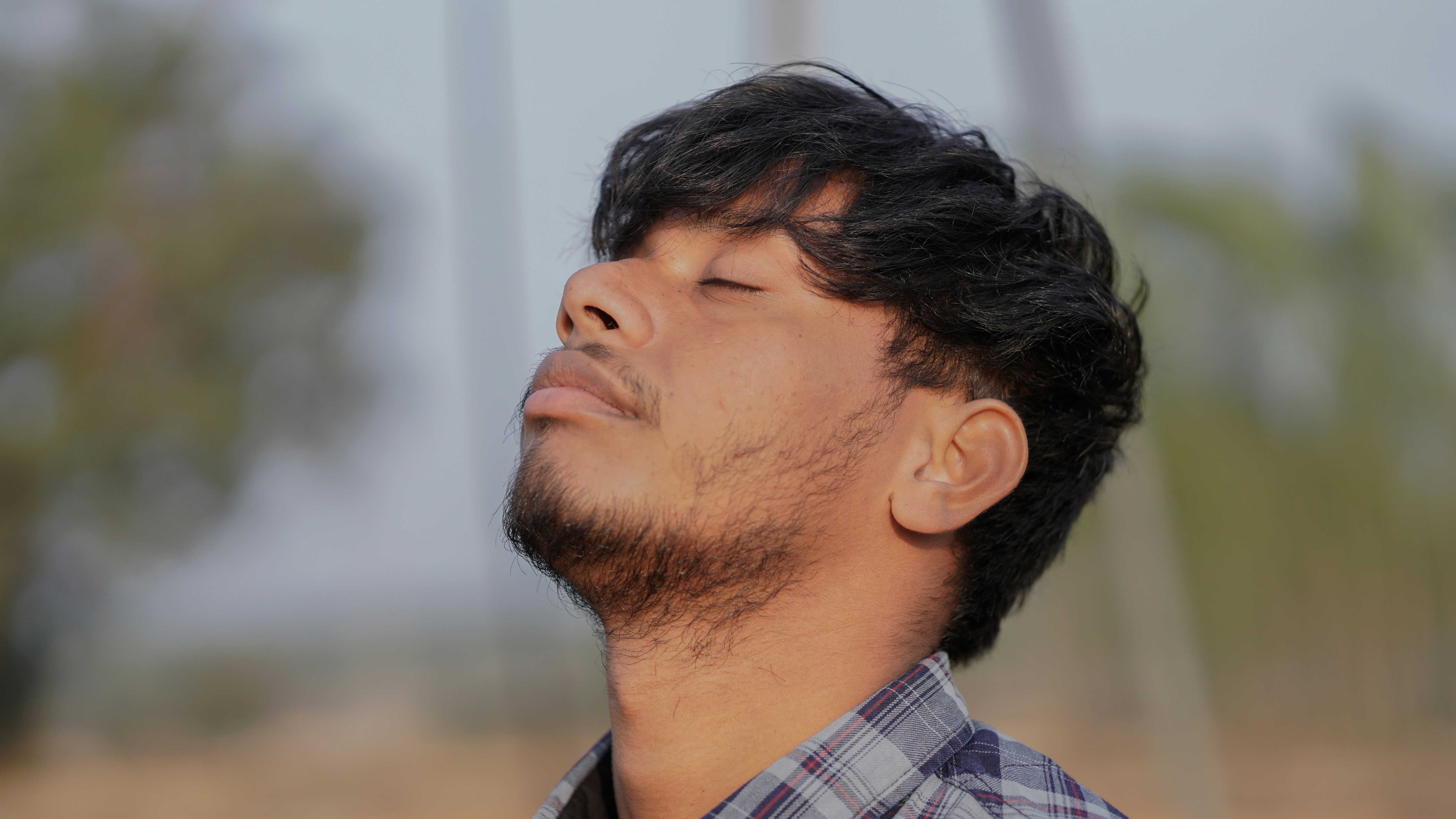 a man with his eyes closed looking up