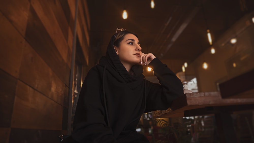 a woman sitting on a bench in a dark room