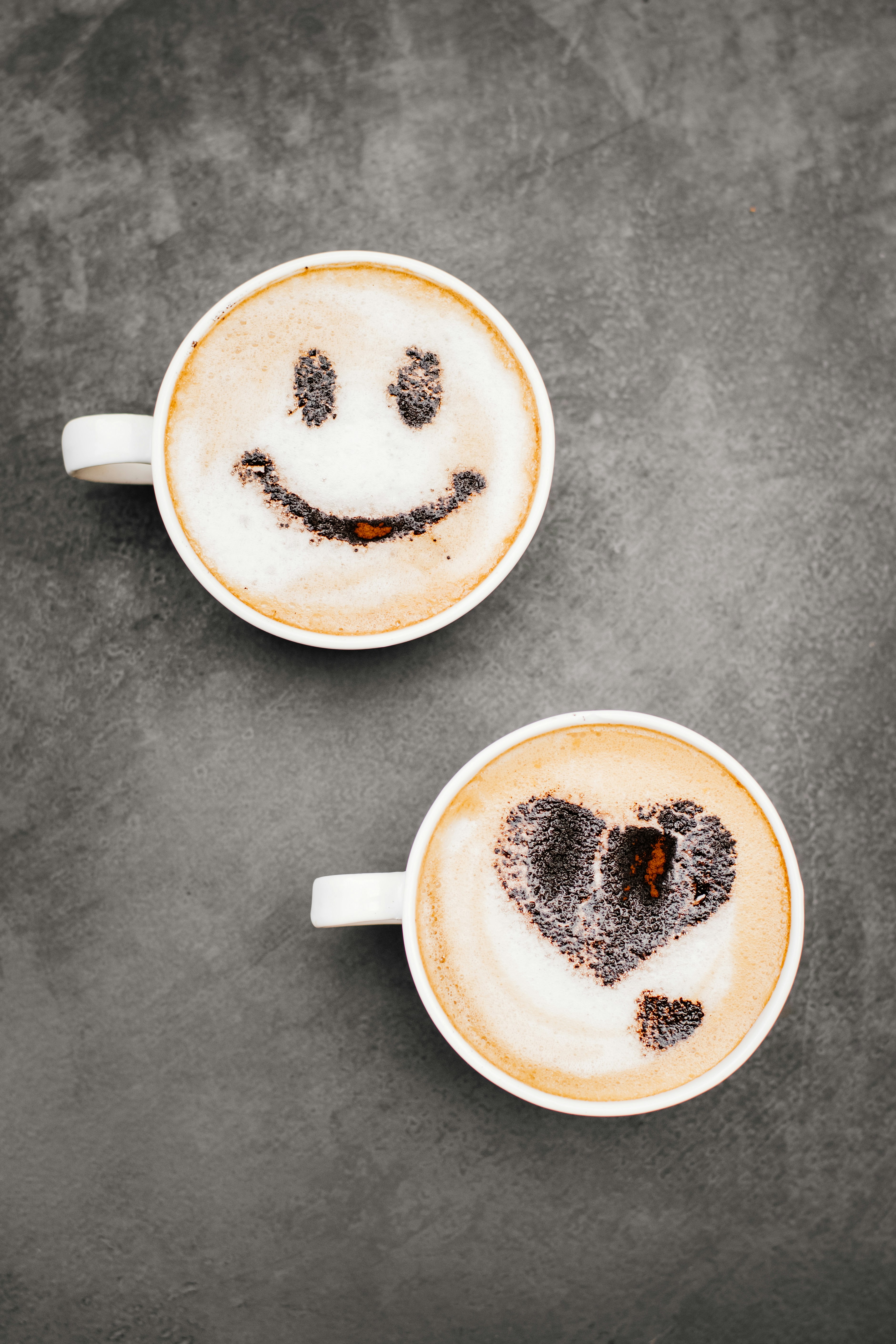 Dos tazas de café con caras sonrientes