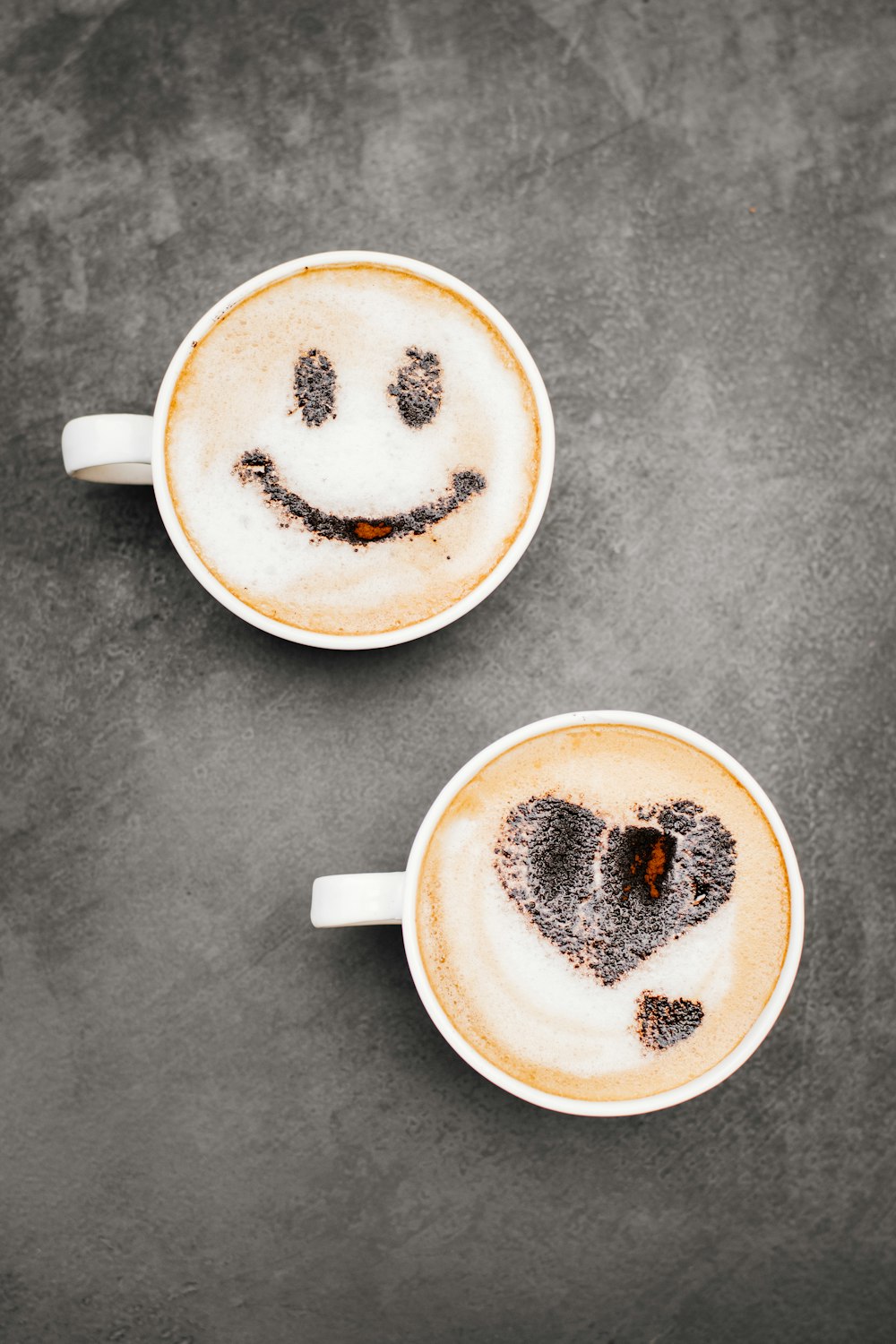 Deux tasses de café avec des visages souriants