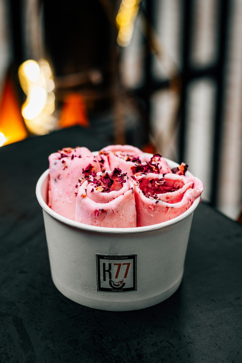a white bowl filled with pink frosting on top of a table