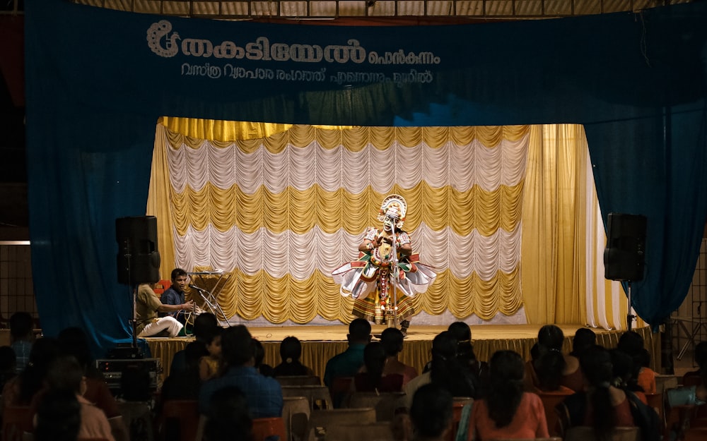 a woman performing a dance on stage in front of a crowd