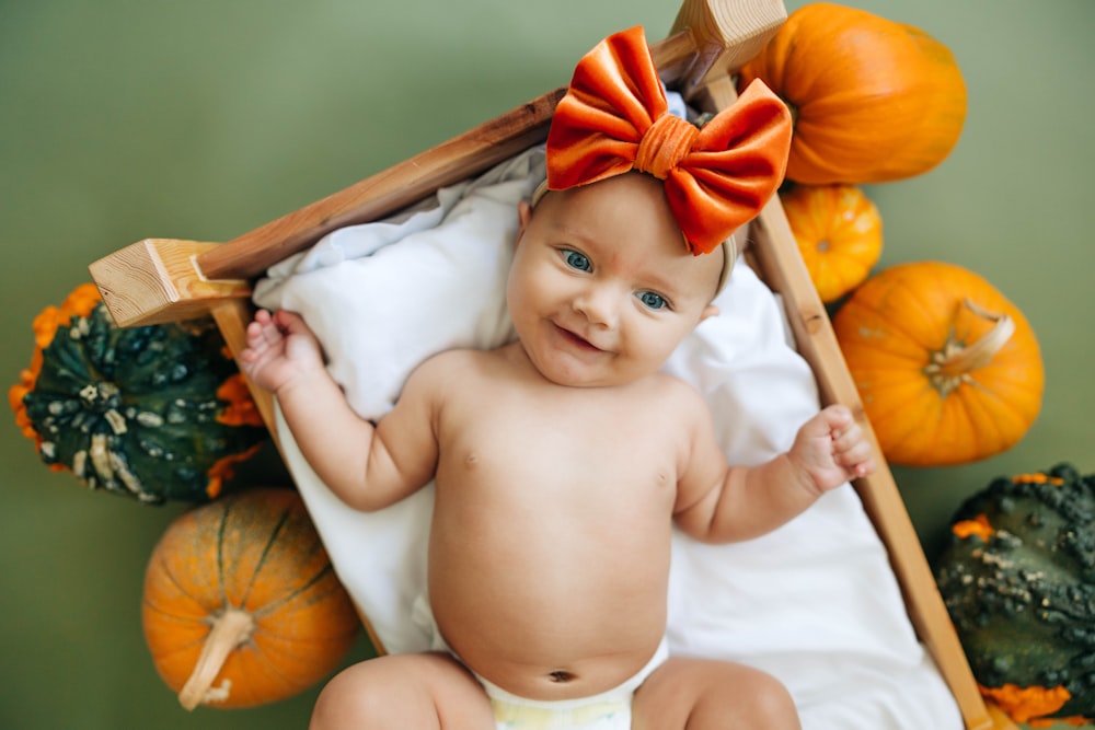 a baby in a diaper with a bow on top of it