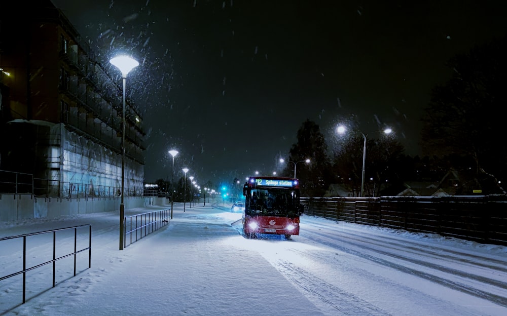 a bus driving down a snowy street at night