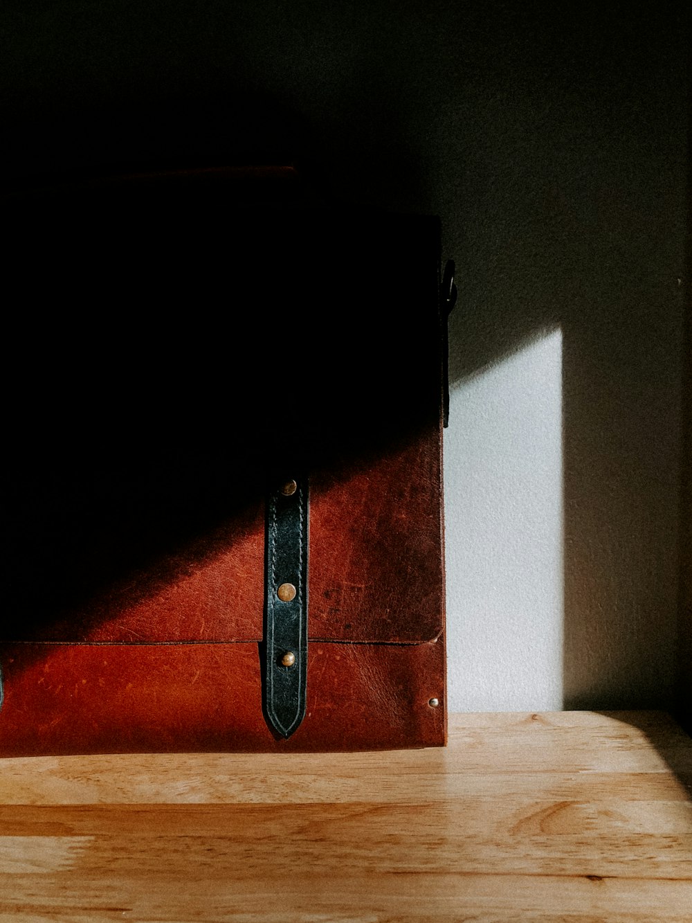 a brown suitcase sitting on top of a wooden table