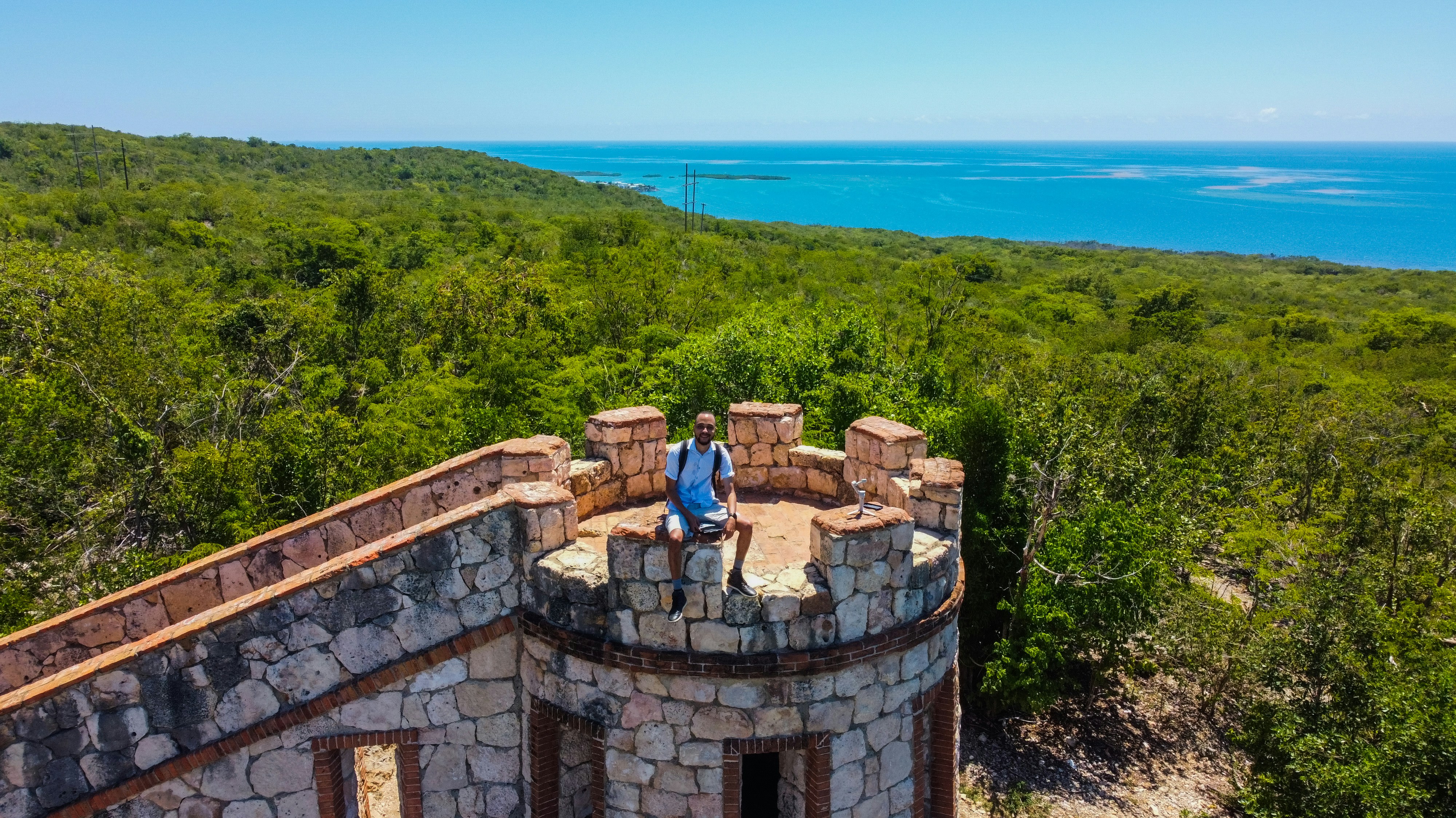 a man sitting on top of a stone tower