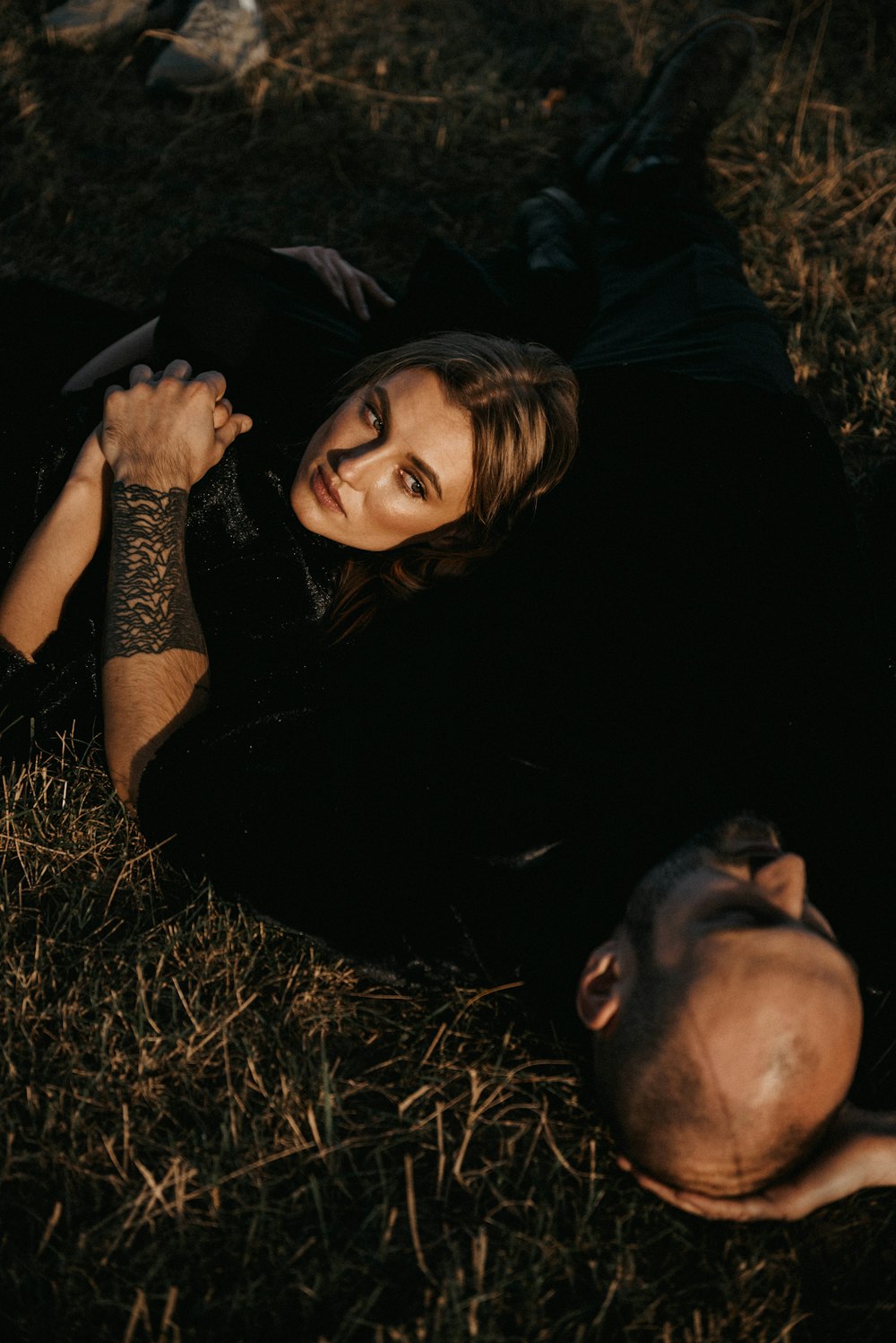 a man laying on the ground next to a woman