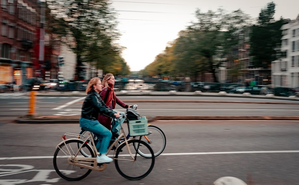 a couple of people riding a bike down a street