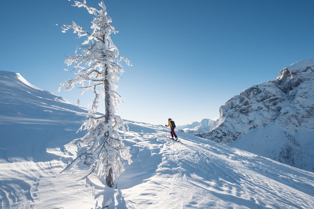 a person riding skis on top of a snow covered slope