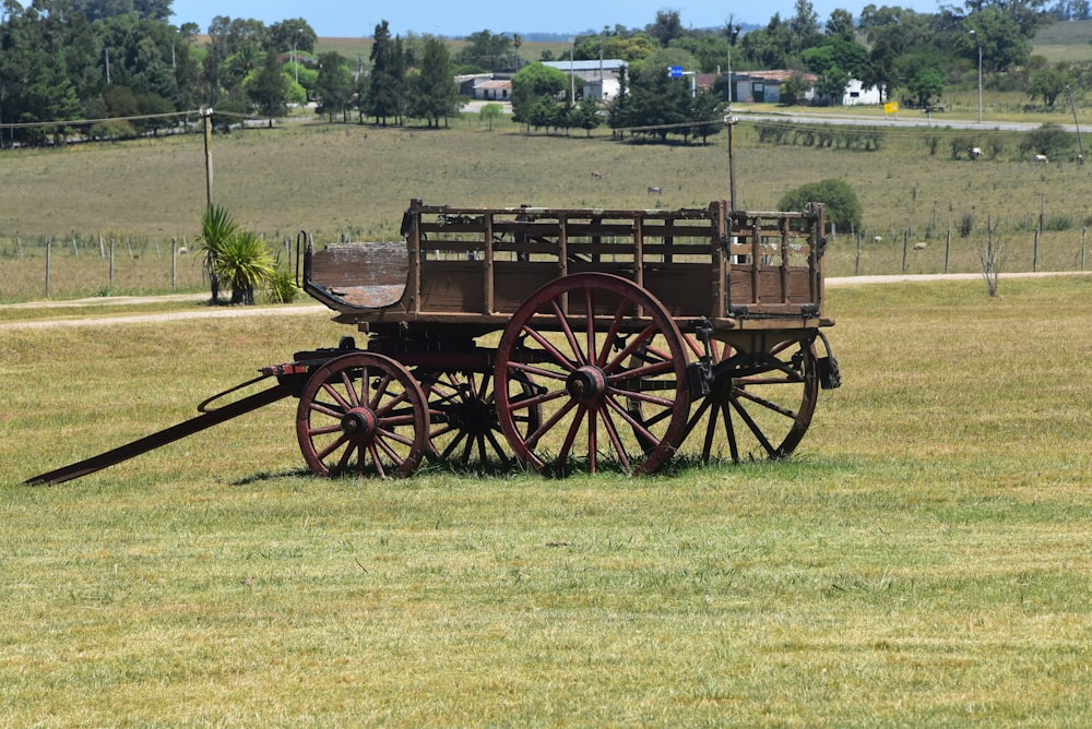 a horse drawn wagon sitting in the middle of a field