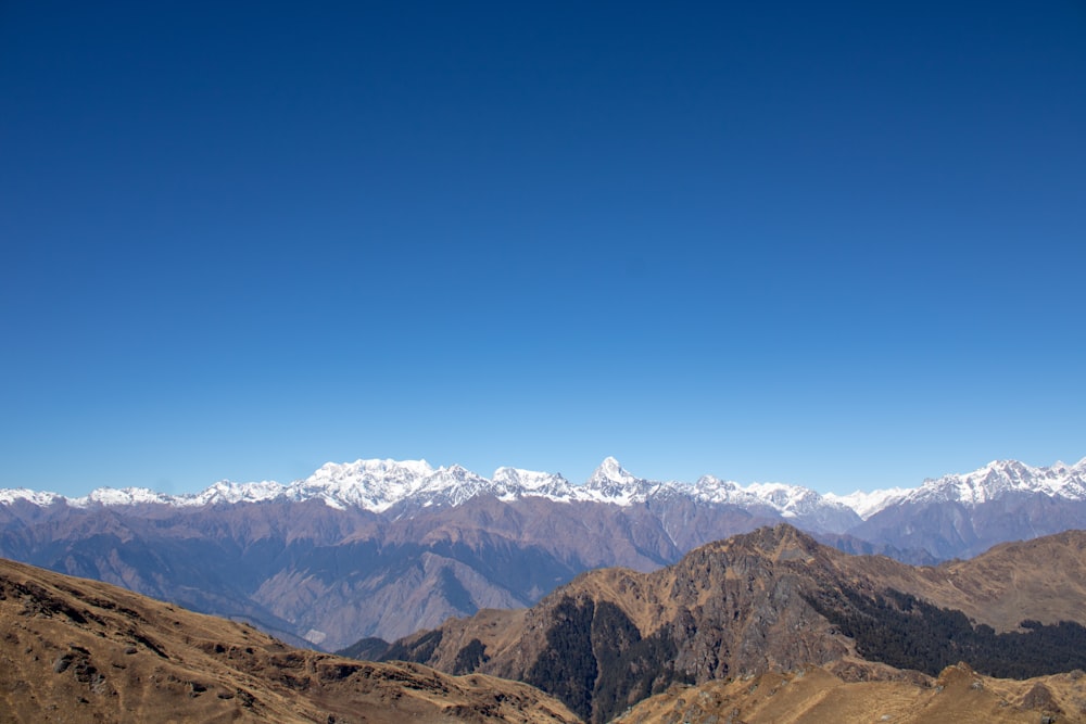 a mountain range with snow capped mountains in the distance