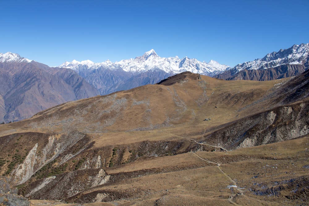 a view of a mountain range with snow capped mountains in the background