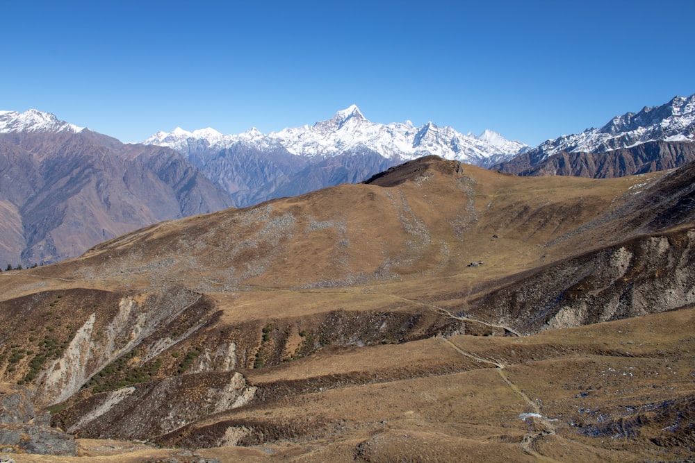 a view of a mountain range with snow capped mountains in the background