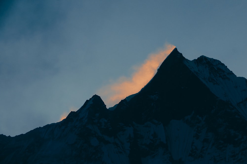 the top of a mountain with a cloud in the sky