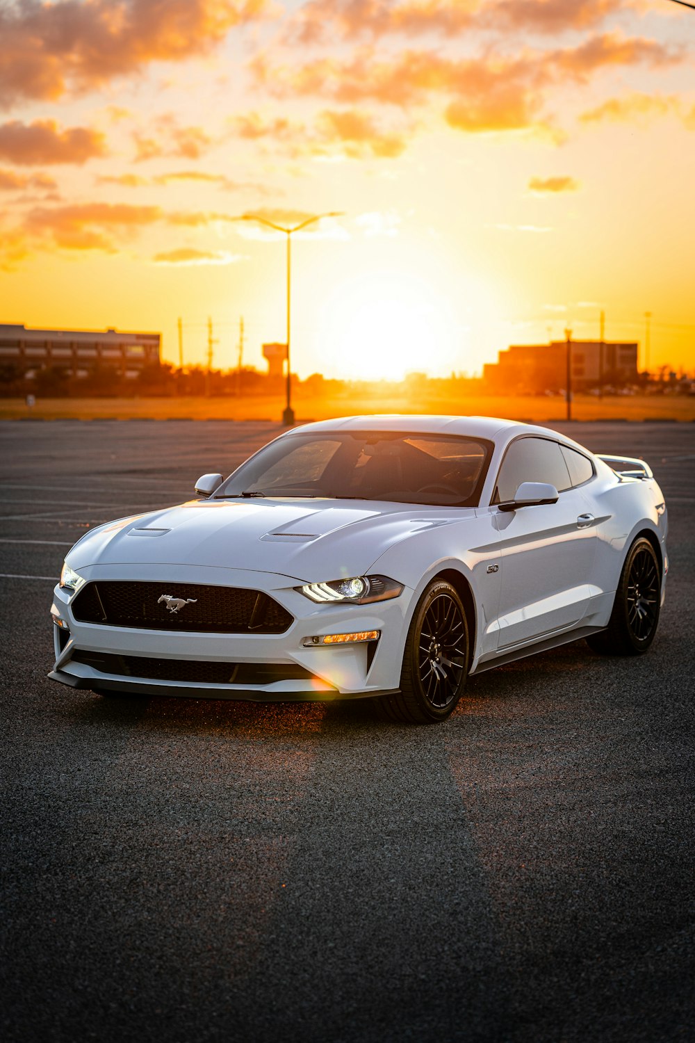 a white car parked in a parking lot at sunset