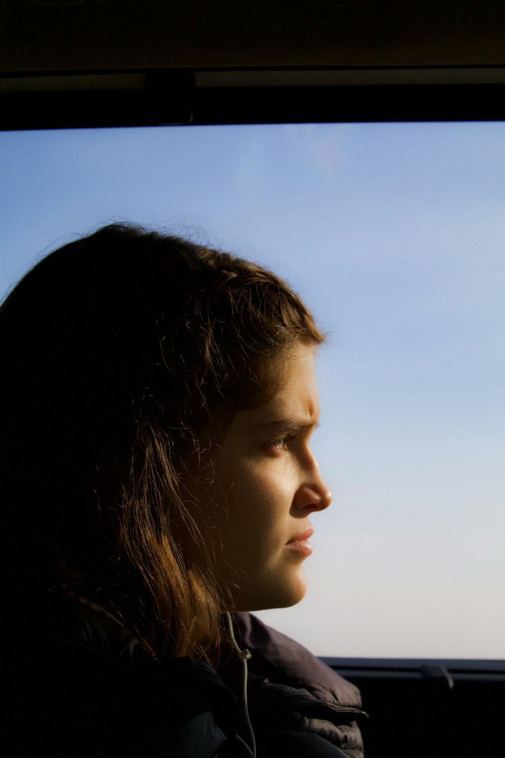 a woman looking out the window of a bus