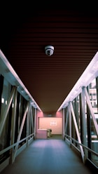 a long hallway with metal railings and a ceiling light